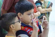 Two boys looking at a smartphone together, illustrating children and mobile platforms