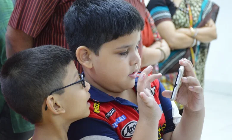 Two boys looking at a smartphone together, illustrating children and mobile platforms