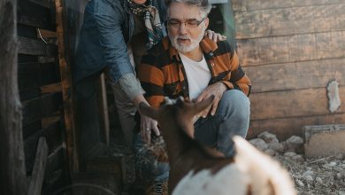 A happy retired couple enjoying life on their smallholding with a goat